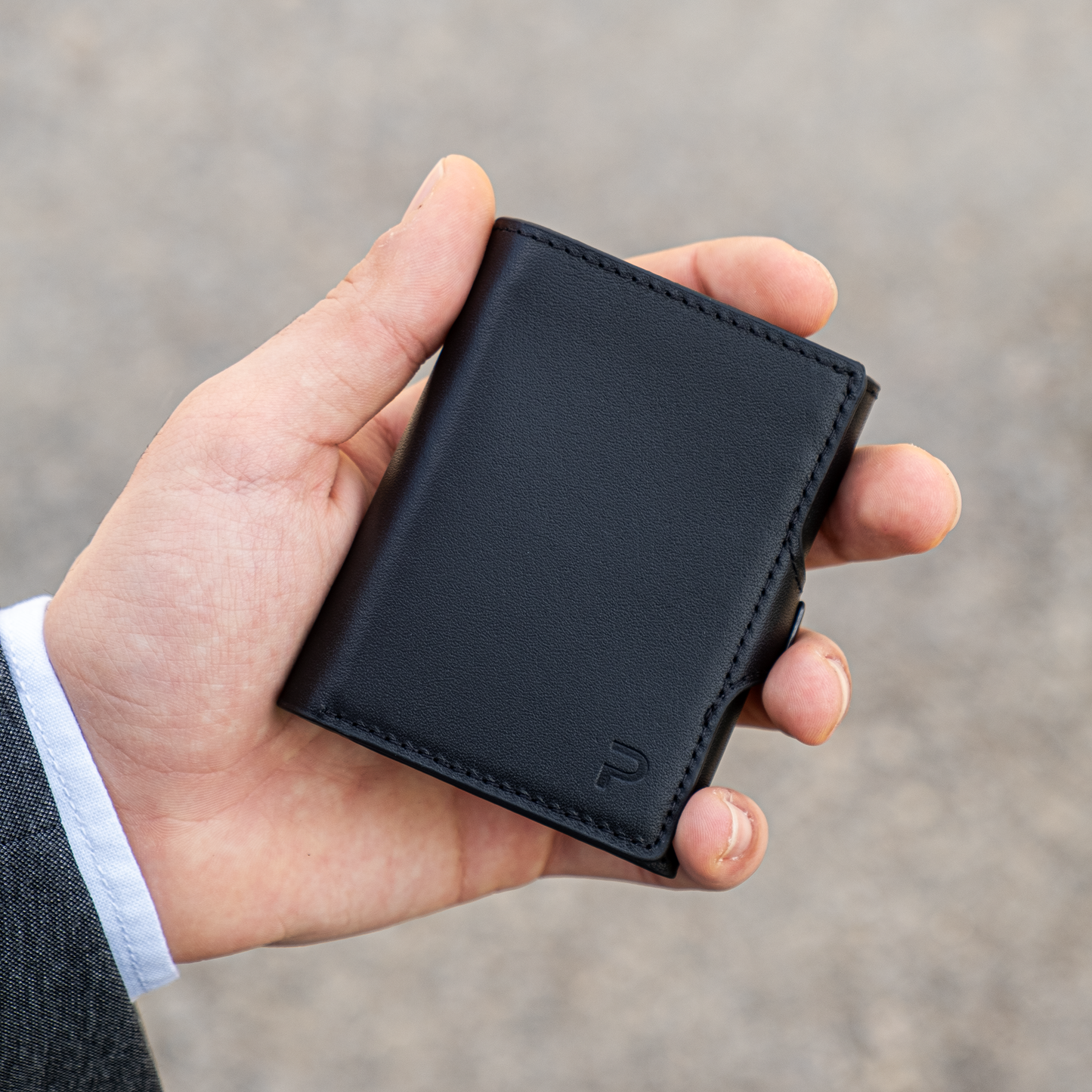 Una mano tiene un portafoglio chiuso in mano, sfondo elegante chiaro