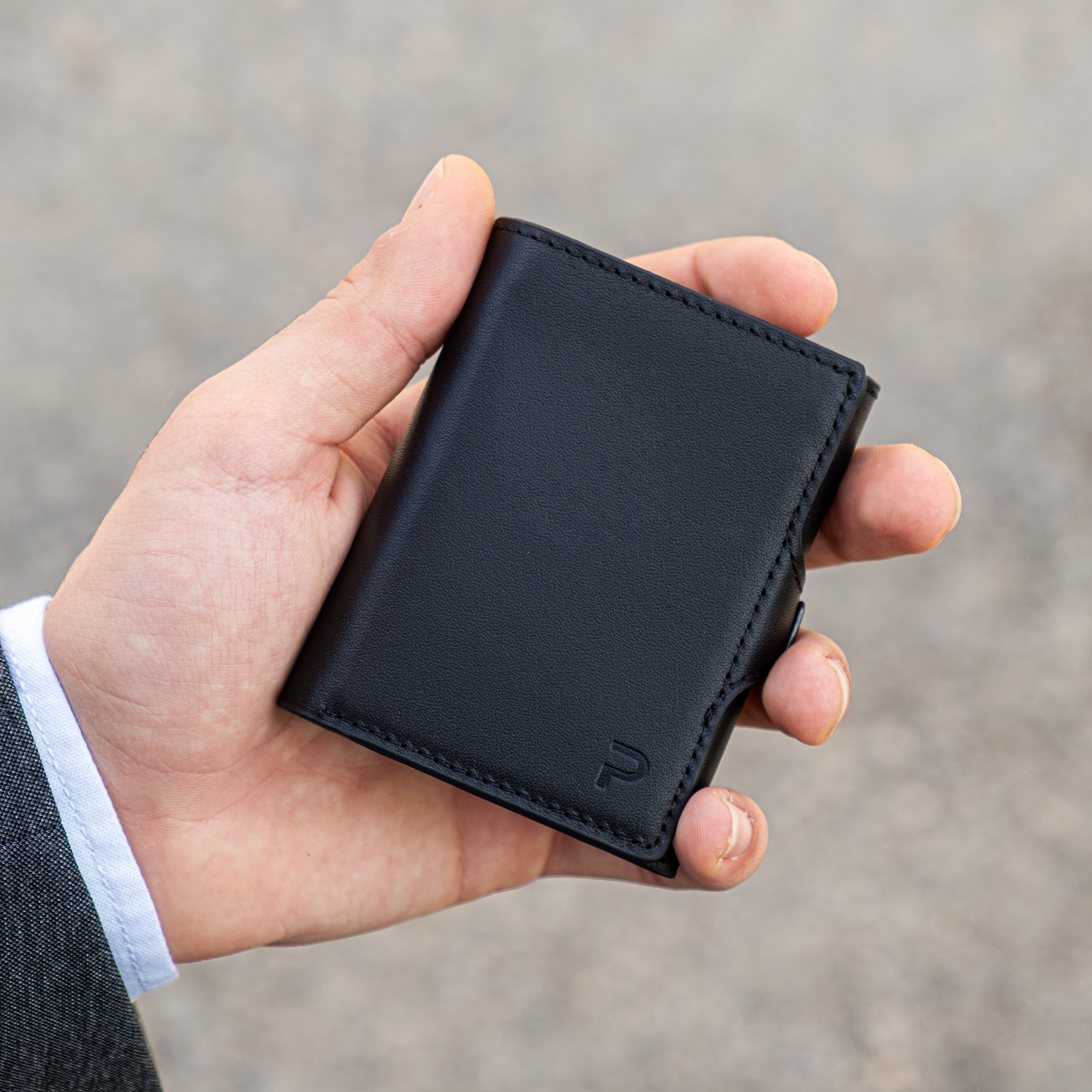 Una mano tiene un portafoglio chiuso in mano, sfondo elegante chiaro